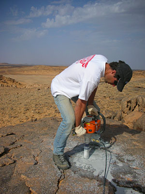 Geologist Seb Luning drilling into Palaeozoic sandstones, southern Libya.